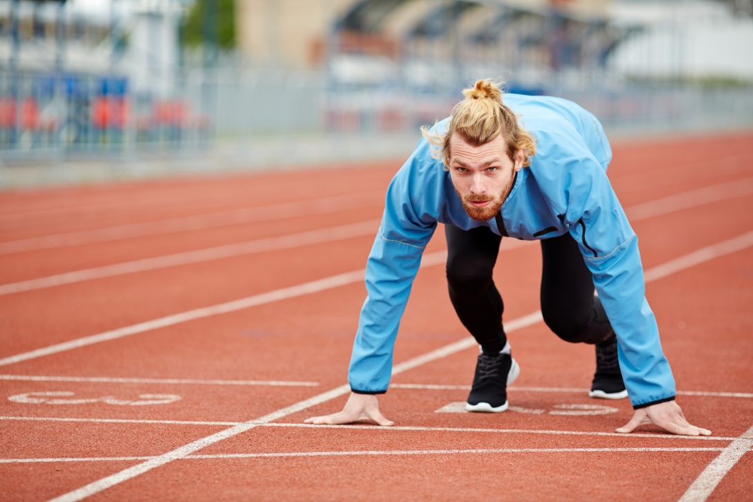 Un coach sur un terrain de foot en train d'expliquer une tactique à 2 joueuses